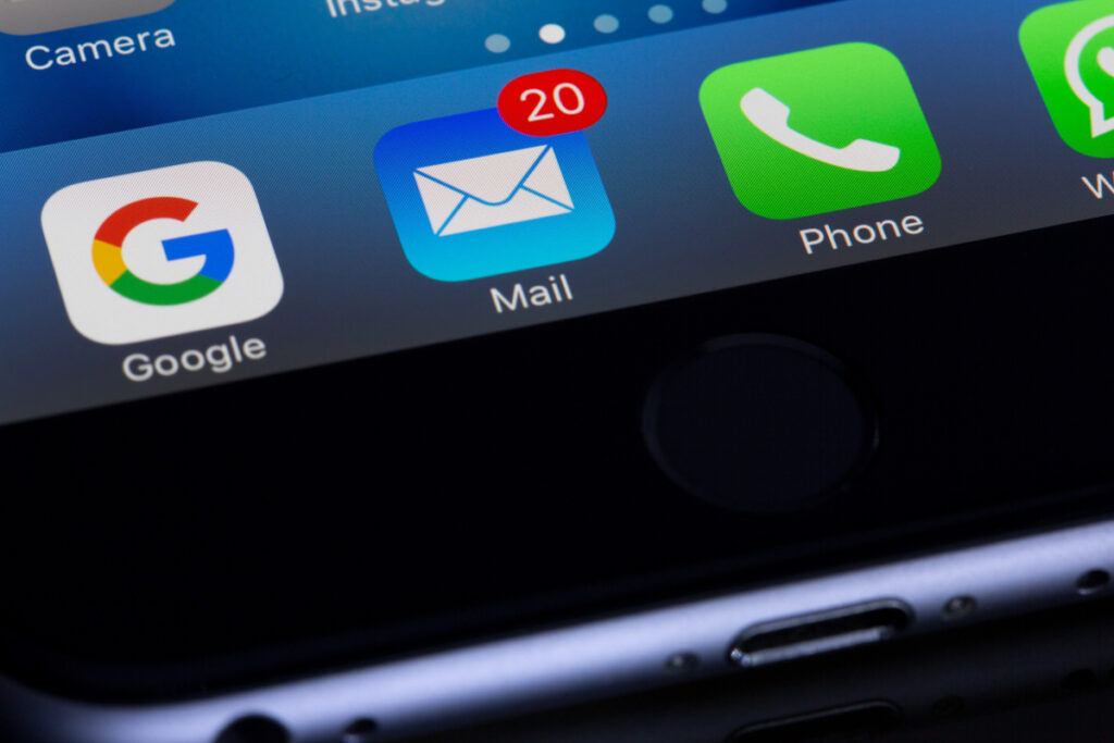 Photo of email apps on an iPhone screen including Google and the iOS Mail app.